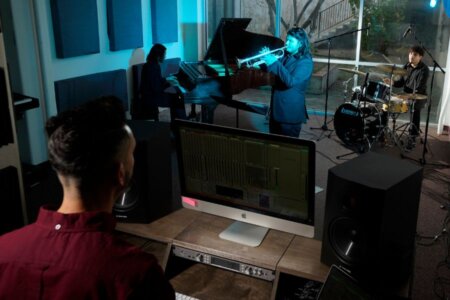 Music faculty Michael Gómez stands at the controls as students play jazz in the new Rattler Records studio.