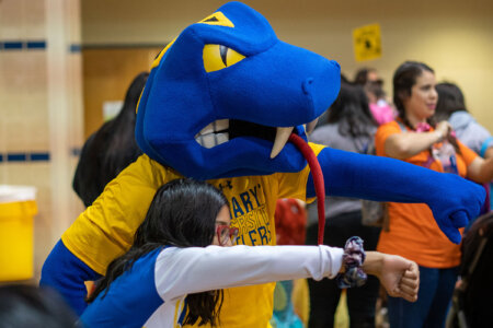Rattler Man poses with a student during the annual Boo Bash