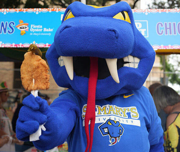 Rattler Man holds out a chicken on a stick during Homecoming Bake.