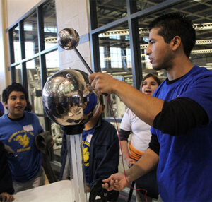 A student from St. Mary's University shows off a science experiment to elementary students.