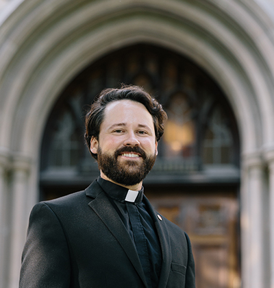 William Hayes wears his clerical collar with a dark jacket at Fordham University in New York.