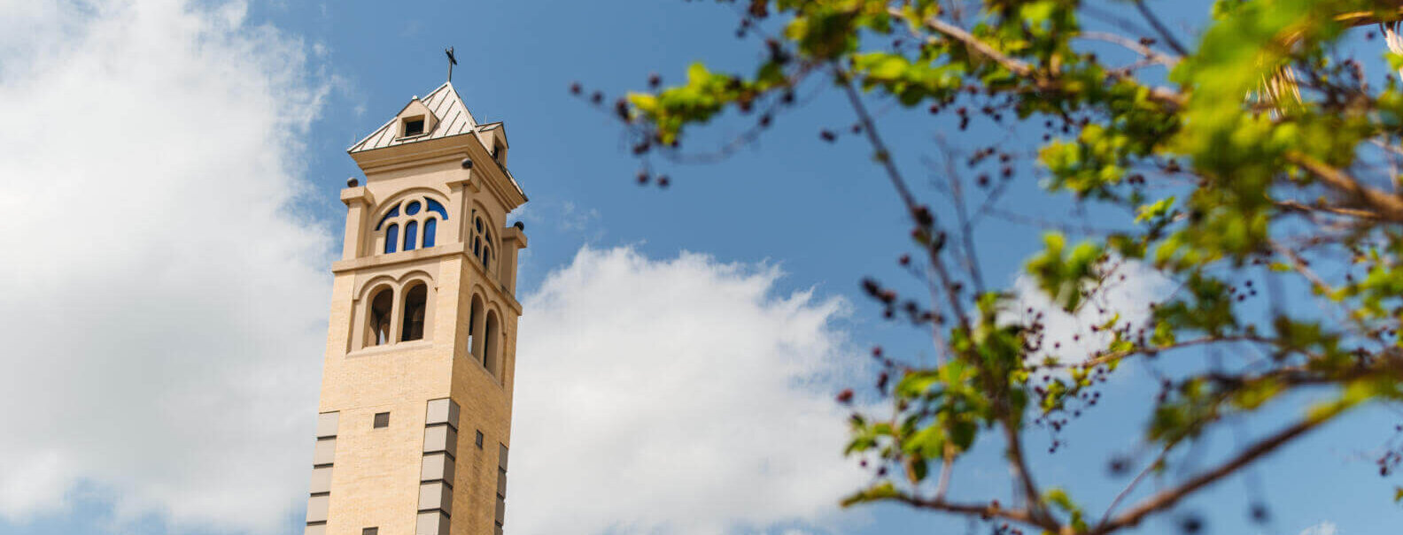 Light shines behind the bell tower.