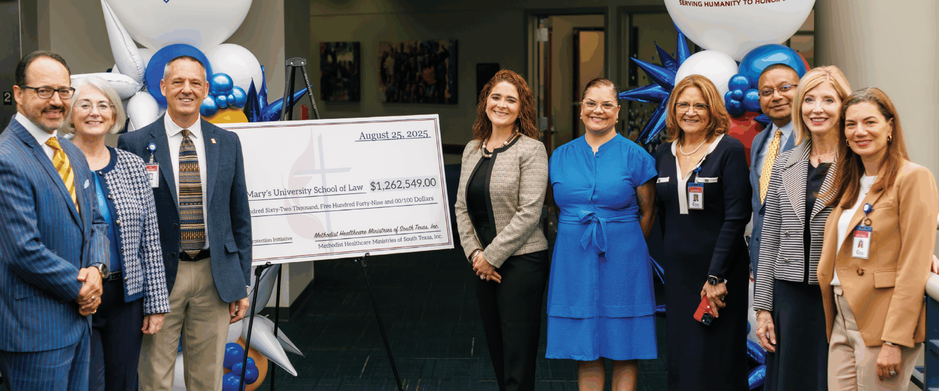 Ten representatives from St. Mary's University and the Methodist Healthcare Ministries stand on either side of a giant check for $1.2 million.
