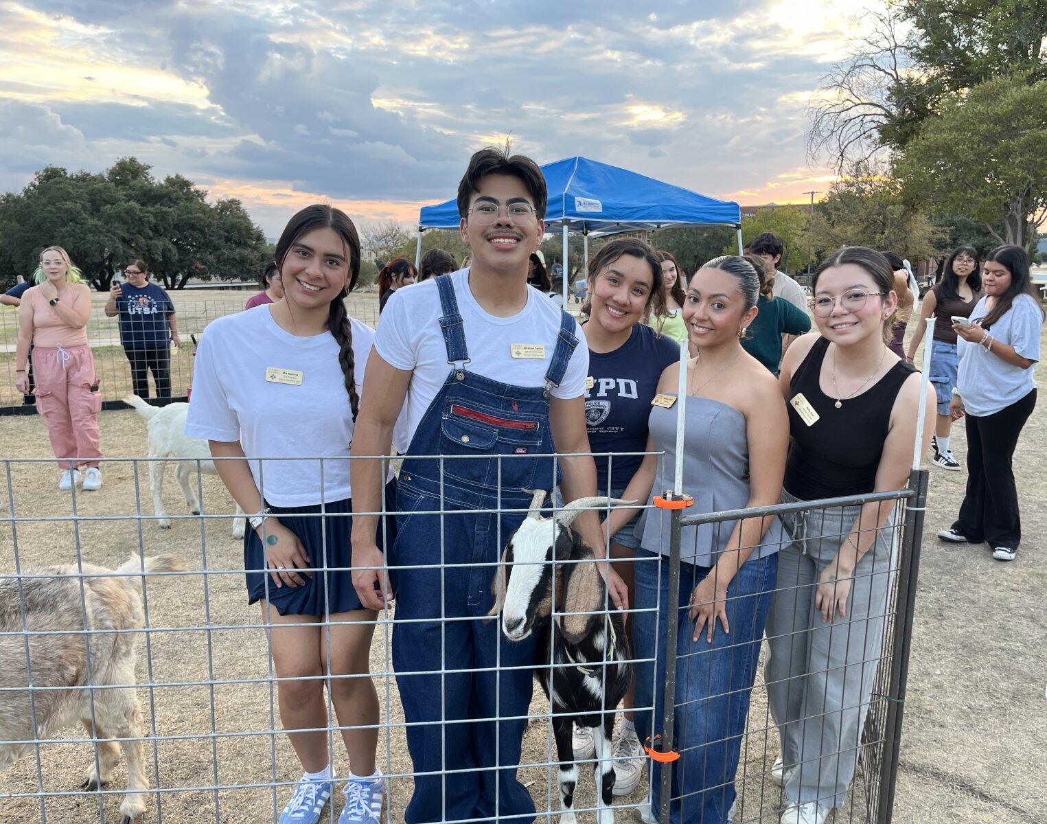 Students take a photo with a goat on the St. Mary's University campus in the petting zoo during an event.