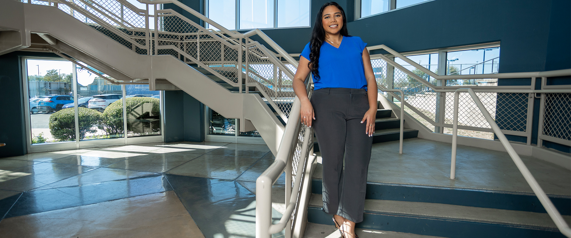 ShaLi Niu (M.P.A. ’25) stand on the stairs in the AA&CC.
