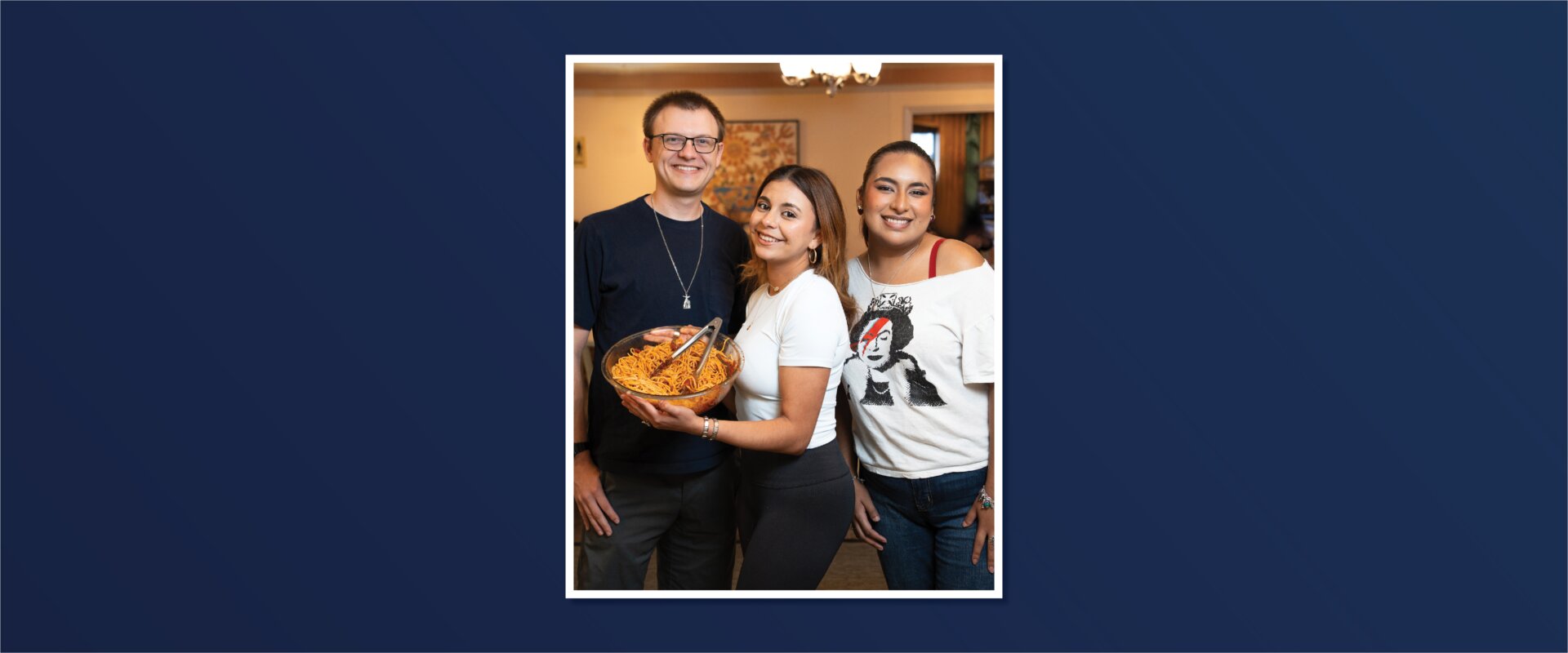 Marianist Novice Paul Pruski and St. Mary's University students Viana Galindo and Cristina Duque share in the spaghetti at a Casa Tuesday dinner in April 2025.