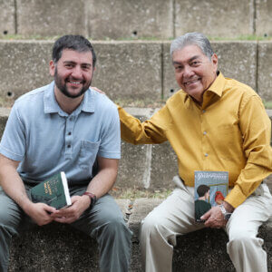 Alex Salinas (B.A. '11, M.A. '19), left, and Rafael Castillo (B.A. '75), visit the St. Mary's amphitheater with their new works of fiction.
