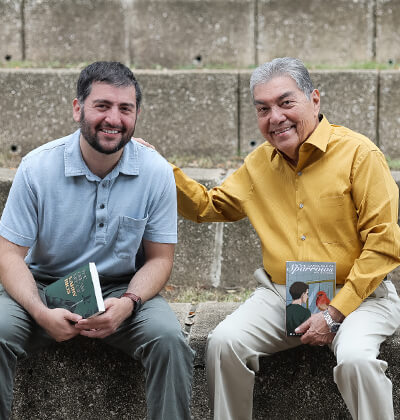 Alex Salinas (B.A. '11, M.A. '19), left, and Rafael Castillo (B.A. '75), visit the St. Mary's amphitheater with their new works of fiction.