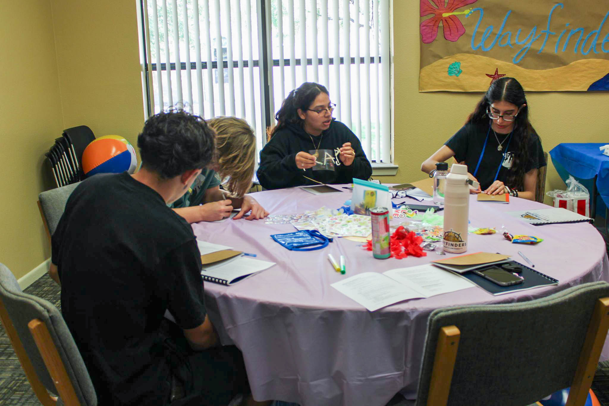 Students sitting at a table together reflecting on what they have learned.