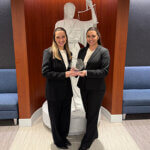 Kendall Michaelis and Caroline Villarreal hold the national championship trophy for winning the ABA National Negotiation Competition in Chicago.