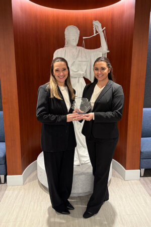 Kendall Michaelis and Caroline Villarreal hold the national championship trophy for winning the ABA National Negotiation Competition in Chicago.