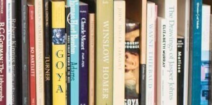 Books lined up in a bookshelf.