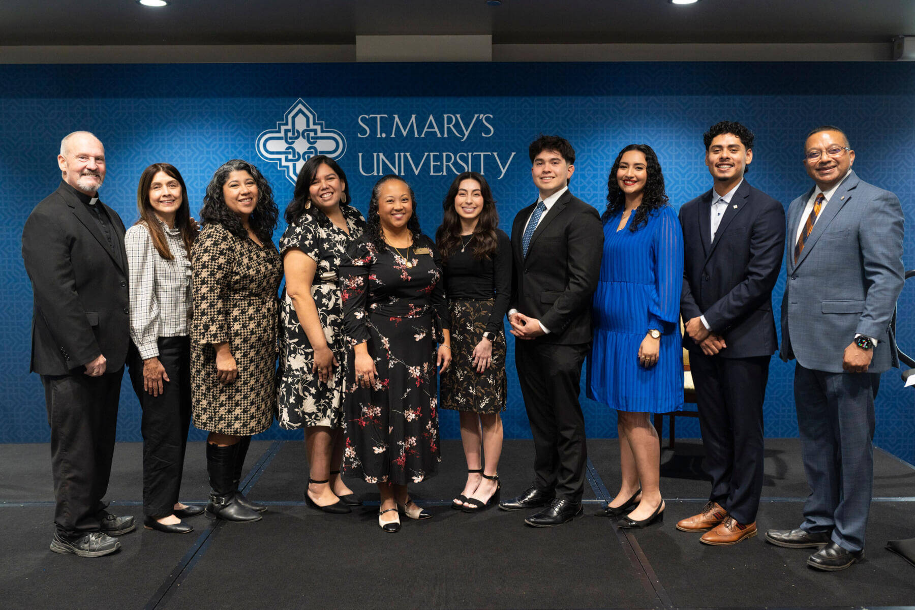 (From Left to Right) Father John Thompson with the 2026 Marianist Heritage Award Recipients: Rose Mary Gallegos, Alyssa Leffall, Amy Arismendez and Gretchen Luistro-Bernal and students Lucia Martinez, Rafael Portillo, Arely Reyes and Emmanuel Varela next to President Erevelles.