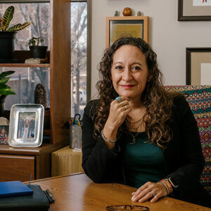 Andrea Beleno Harrington, J.D., sits at her desk in her office in the Center for Legal and Social Justice building.