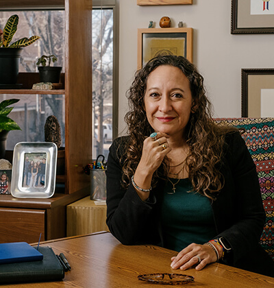 Andrea Beleno Harrington, J.D., sits at her desk in her office in the Center for Legal and Social Justice building.