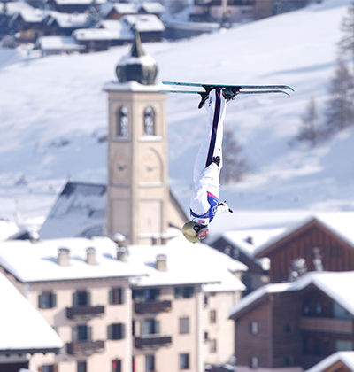 Photo of Olympian Winter Vinecki caught upside down in the air as she competes in the 2026 Winter Olympics in Italy.