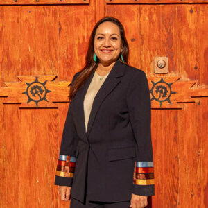 Christine Serrano (B.B.A. ’95, M.B.A. ’99) in front of church door at Ysleta del Sur Pueblo.