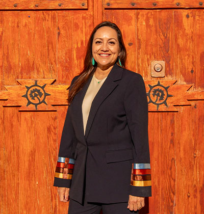 Christine Serrano (B.B.A. ’95, M.B.A. ’99) in front of church door at Ysleta del Sur Pueblo.