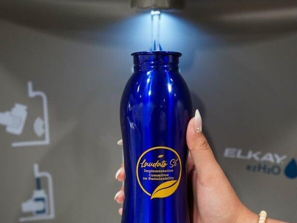 A staff member fills up her Laudato Si' water bottle at a new water bottle refilling station on the third floor of St. Louis Hall.