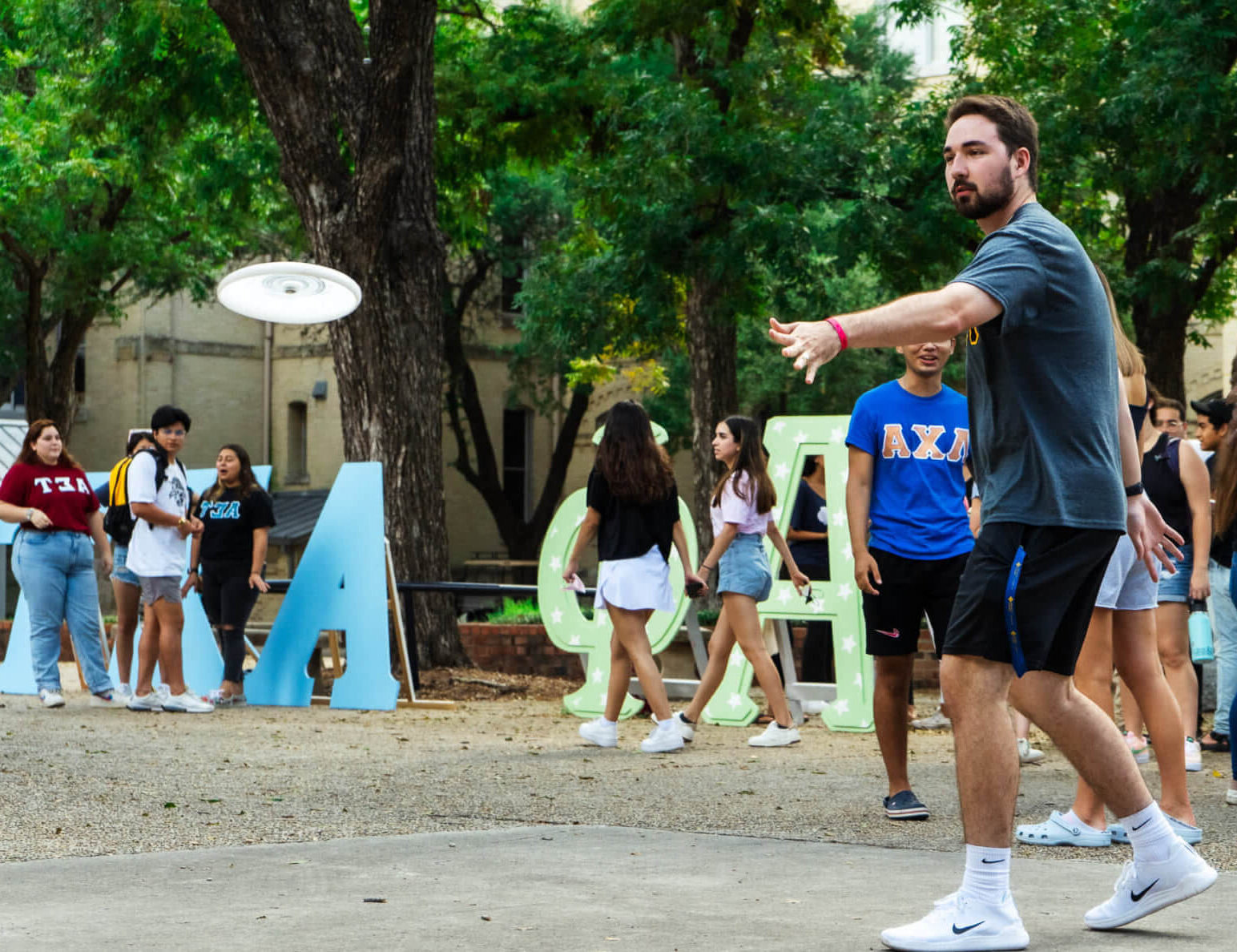 A group of students play frisbee together in the Quad.