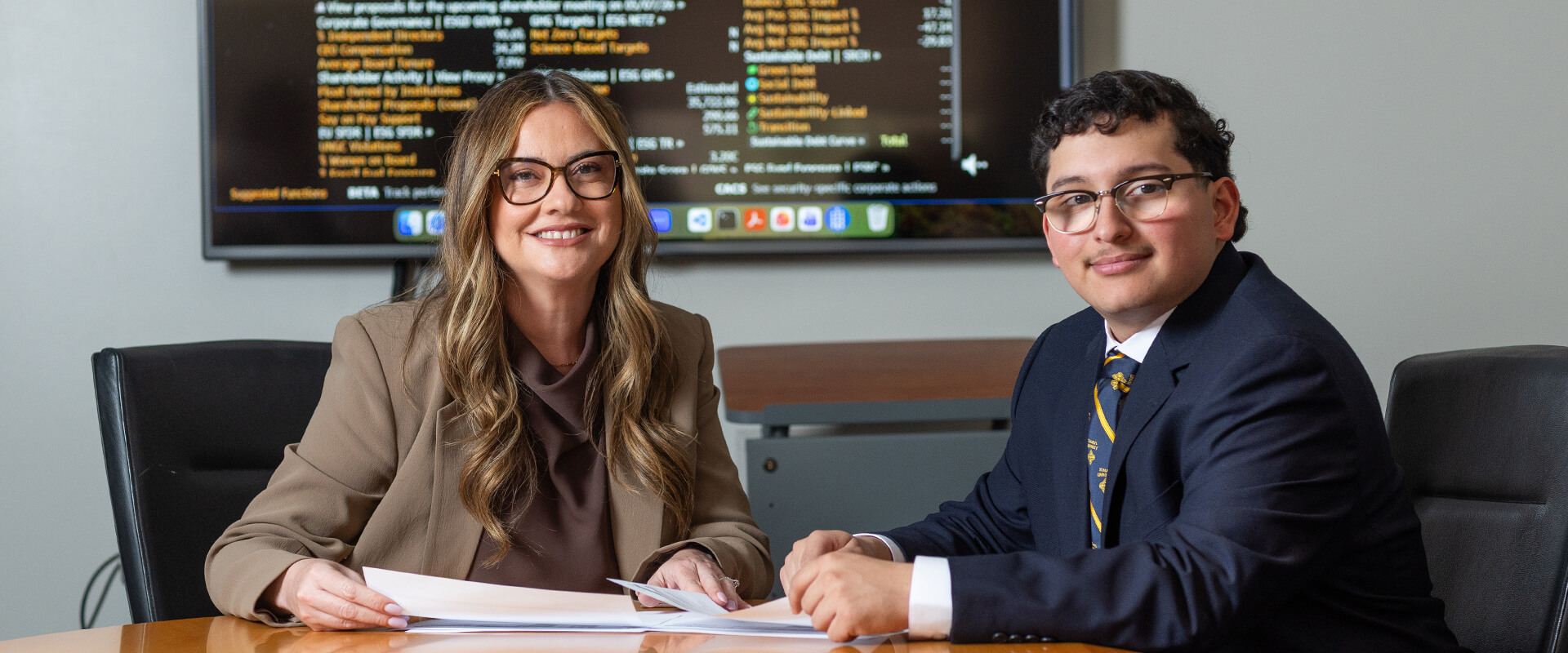 In the Albert B. Alkek Business Building, Professor Violeta Díaz, Ph.D., left, and Richard J. Rodriguez (B.B.A. ’26) review market data via the Bloomberg Terminal.