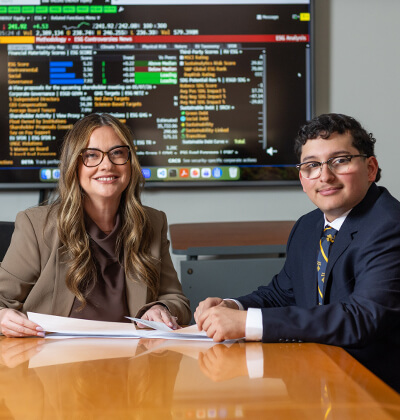 In the Albert B. Alkek Business Building, Professor Violeta Díaz, Ph.D., left, and Richard J. Rodriguez (B.B.A. ’26) review market data via the Bloomberg Terminal.