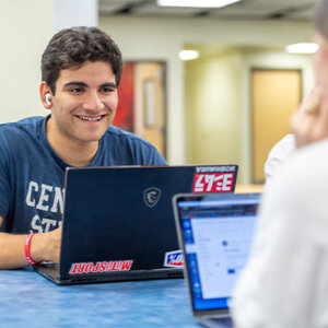 A male student talks to a female student in the Commons.
