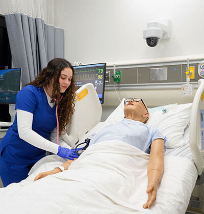 A student practices on a manikin in the simulation lab at St. Mary's University.