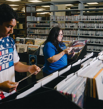 From left, Nicholas Galus, a junior, and Valerie Vallejo, graduate Public History student and an Archives Graduate Assistant for the Blume Library, review their vinyl options.