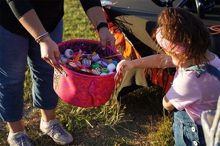 A trick-or-treater picks an item out of a bucket at Boo Bash 2025.